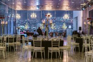 a banquet hall with tables and chairs and chandeliers at Terrado Suites Antofagasta in Antofagasta +30 photos