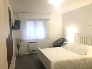 a bedroom with a white bed and a window at L'IDEAL 112 - 85m2, 2 chambres, Parking & Cabine de plage in Deauville
