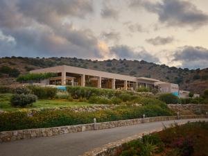 a building on top of a hill with a road at Domes Aulus Elounda, Adults only, Curio Collection by Hilton in Elounda