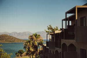 a building with a view of the water and mountains at Domes Aulus Elounda, Adults only, Curio Collection by Hilton in Elounda