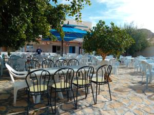 a group of tables with white chairs and trees at dar fatma matmata in Matmata