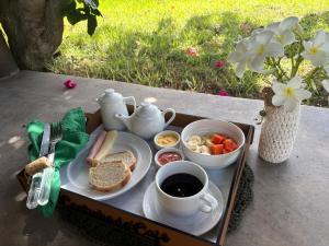 a lunch box with a tray of food and a cup of coffee at Rancho Capilé Suítes à Beira Mar in Japaratinga
