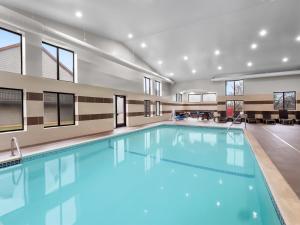 a swimming pool with blue water in a building at Spark By Hilton Ann Arbor South in Ann Arbor