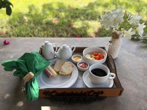 a tray with a tray of breakfast food on a table at Rancho Capilé Suítes à Beira Mar in Japaratinga