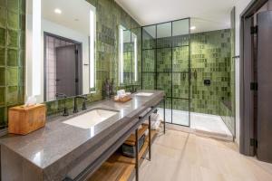 a bathroom with two sinks and a shower at The Key Hotel Dubuque, Tapestry Collection By Hilton in Dubuque +8 photos