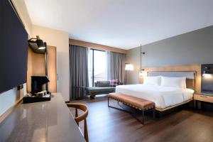 a large hotel room with a bed and a desk at The Key Hotel Dubuque, Tapestry Collection By Hilton in Dubuque