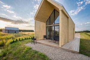 a house with a large window and a wooden deck at Palanga Waterhouse in Kiauleikiai