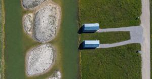 two blue pavilions in a field with grass at Palanga Waterhouse in Kiauleikiai