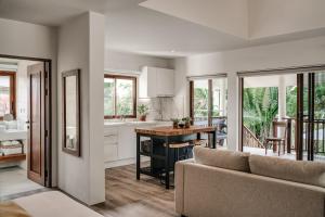 a kitchen and living room with a couch and a table at Sontaya - Lakeside Studio Villa in Ban Khao Thong