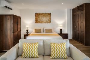 a bedroom with a large bed and a couch at Sontaya - Lakeside Studio Villa in Ban Khao Thong