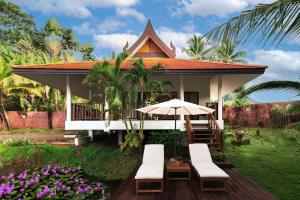 a house with a deck with chairs and an umbrella at Sontaya - Lakeside Studio Villa in Ban Khao Thong