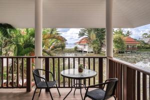 a patio with a table and chairs on a balcony at Sontaya - Lakeside Studio Villa in Ban Khao Thong +4 photos