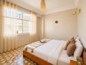 a bedroom with a bed and a large window at Cozy Guesthouse in Aourir near Tamraght in Aourir