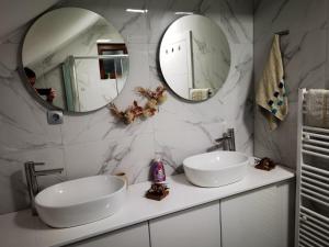 a bathroom with two sinks and two mirrors at Danin's Home in Tuzla