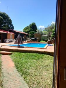 a swimming pool with an umbrella in a yard at Hospedaje Cabaña Completa in Rivera +11 photos