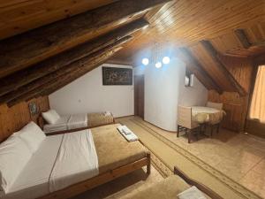a attic bedroom with two beds and a desk at Guest House Argjiro Castle in Gjirokastër