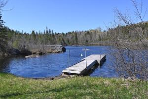 a dock in the middle of a lake at SPA private pond and beach volleyball in Lac-Superieur