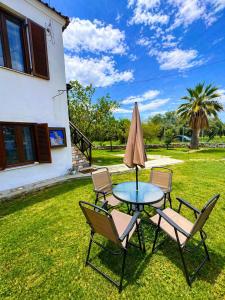 a patio with a table and chairs and an umbrella at Elia & Petra Villa in Prinos
