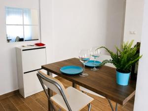 a kitchen with a wooden table and two glasses of wine at Flores in Málaga