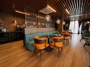 a restaurant with a green couch and tables and chairs at Hotel Fogo Amsterdam in Amsterdam +60 photos