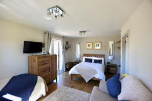 a bedroom with a bed and a couch and a tv at The Paddock at Peacock Farm near Belvoir Castle in Redmile