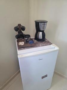 a coffee maker sitting on top of a refrigerator at Pousada Sol Radiante in São Pedro da Aldeia
