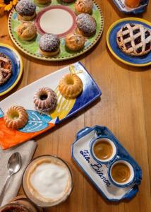 a table with plates of donuts and cups of coffee at B&B Zia Bianca in Vietri sul Mare