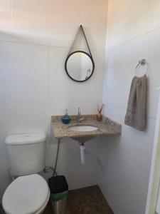 a bathroom with a toilet and a sink and a mirror at Pousada Sol Radiante in São Pedro da Aldeia +41 photos