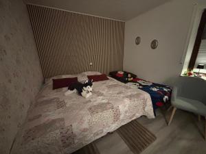 a black and white dog sitting on a bed at Ferienwohnung Waldblick in Winterberg