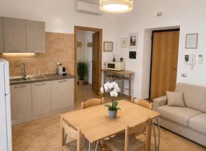 a kitchen and living room with a table and a couch at Casa Rosada Alghero in Alghero