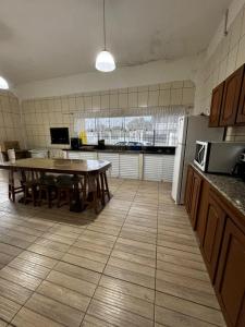 a kitchen with a table and a dining room at Sobrado Itapoá in Itapoa