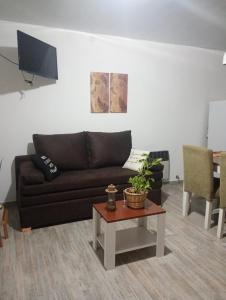 a living room with a black couch and a table at La casita de Susi in San Pedro