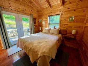 a bedroom with a bed in a log cabin at Just Right- RRG -Relaxing - Secluded in Slade