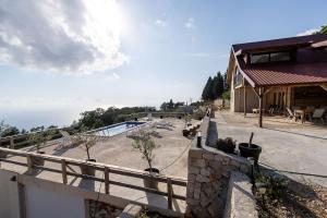 a house with a fence and a swimming pool at Olive Panorama Villa in Dobra Voda +31 photos