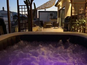 a hot tub on the balcony of a house at Luxury Domus Apartment in SantʼAgata di Militello