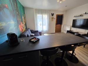 a living room with a large black table and chairs at Studio à 2 pas de Disneyland in Esbly