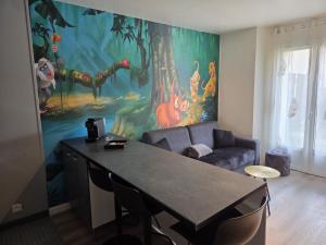 a living room with a large painting on the wall at Studio à 2 pas de Disneyland in Esbly