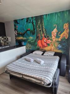 a bedroom with a wall with a painting of dogs at Studio à 2 pas de Disneyland in Esbly +23 photos