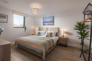 a bedroom with a bed and a potted plant at Luxury Sea View Apartments in Bude with Garden, Sleep 6 in Bude