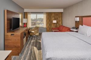 a hotel room with a bed and a flat screen tv at Hampton Inn Anchorage in Anchorage