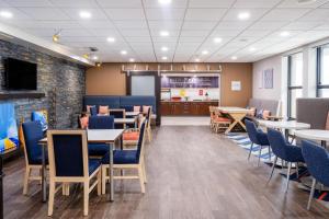 a dining room with tables and chairs and a tv at Hampton Inn Auburn in Auburn