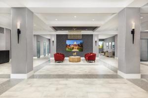 a lobby with two red chairs and a table at Doubletree By Hilton Concord Downtown in Concord