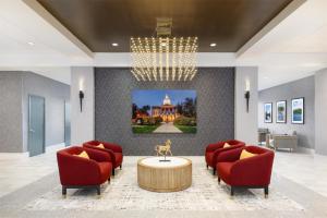 a lobby with red chairs and a table and a chandelier at Doubletree By Hilton Concord Downtown in Concord