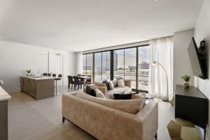 a living room with two couches and a kitchen at The Theodore New Orleans in New Orleans