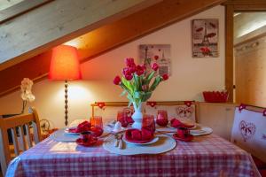 a table with red tulips in a vase on it at Chalet Adda - Appartamento mansarda con garage privato in Bormio