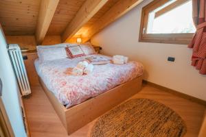 a small bedroom with a bed in a log cabin at Chalet Adda - Appartamento mansarda con garage privato in Bormio +35 photos