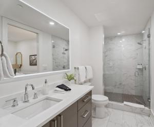 a white bathroom with a sink and a shower at The Theodore New Orleans in New Orleans +156 photos