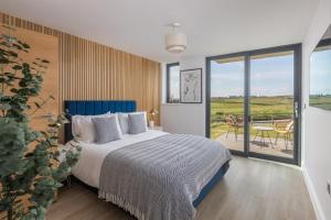 a bedroom with a bed and a balcony with a table at Luxury Sea View Apartments in Bude with Garden, Sleep 6 in Bude