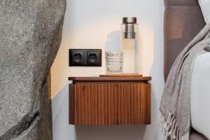 a wooden end table with a bottle on it next to a bed at Hotel Fontana Selb in Selb