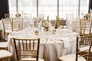 a table set up for a wedding with white tables and chairs at Calgary Marriott Downtown Hotel in Calgary